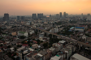 Aerial view of the metropolis at sunset sky, Buildings, roads and electric train routes.