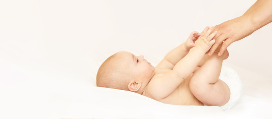 Newborn boy, mother hand. Infant mom massage. funny children change diaper. Home napkin