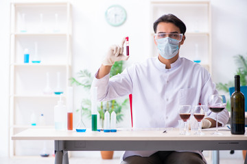 Male chemist examining wine samples at lab