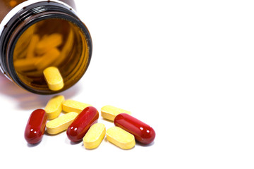 Drug bottle pouring out medicine pills or vitamin isolated.