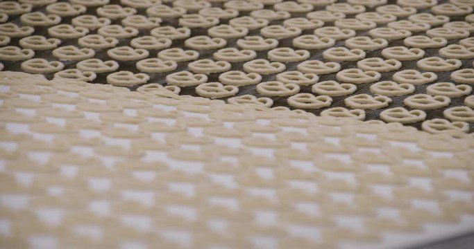 Snacks production Closeup conveyor, raw pretzel ready for baking