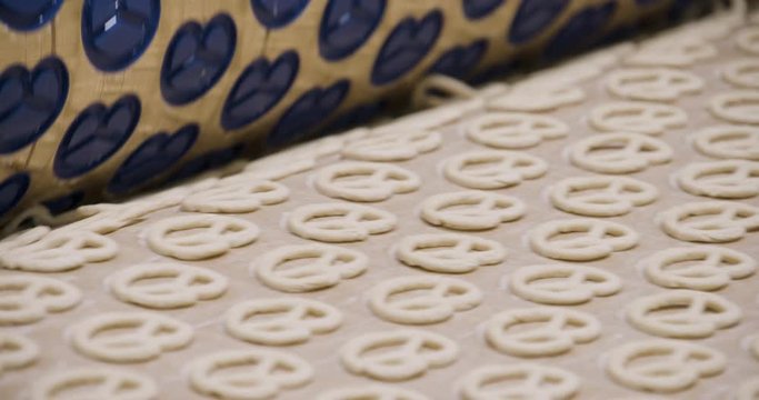 Snacks production Closeup conveyor, raw pretzel ready for baking