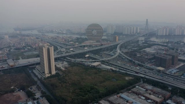 Bird eye view of a huge highway intersection with dense traffic flow with Zhujiang river in the background in the evening, Guangzhou, China