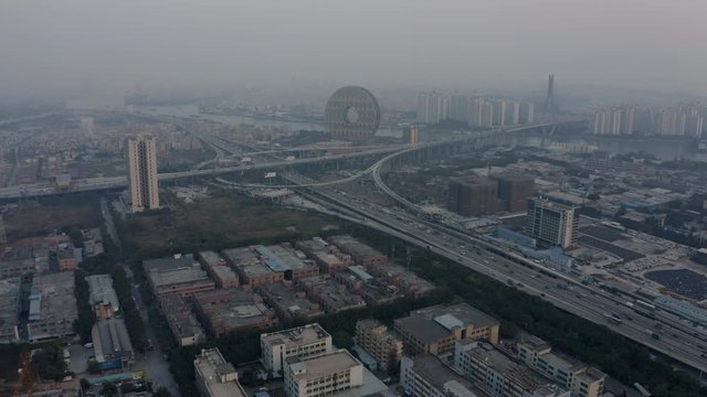 Bird eye view of a huge highway intersection with dense traffic flow with Zhujiang river in the background in the evening, Guangzhou, China