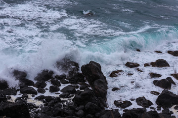 Beautiful Nature scene of sea wave hitting on the black stone shoreline at Jeju Island, South Korea. 