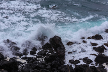 Beautiful Nature scene of sea wave hitting on the black stone shoreline at Jeju Island, South Korea. 