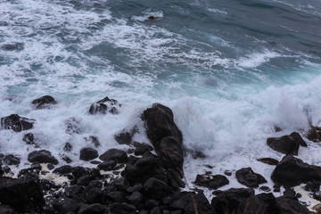 Beautiful Nature scene of sea wave hitting on the black stone shoreline at Jeju Island, South Korea. 