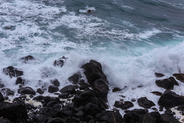 Beautiful Nature scene of sea wave hitting on the black stone shoreline at Jeju Island, South Korea. 