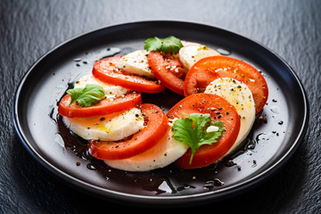 Caprese salad on black stone