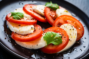 Caprese salad on black stone