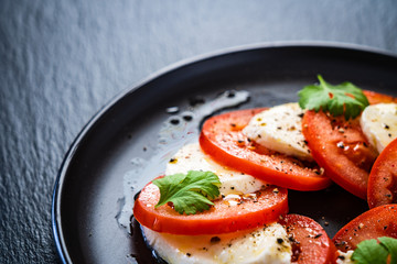 Caprese salad on black stone
