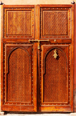 Decorative oriental style wooden entrance door in Marrakesh, Morocco.
