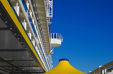 Relaxing on outdoor promenade with sun umbrellas and deck chairs with ocean views on luxury cruise...
