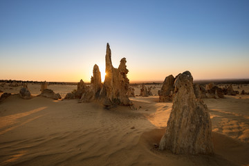 Sun setting behind the limestone stacks in the Pinnacles desert in the Nambung national park located north of Perth in Western Australia