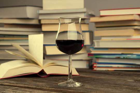 book and lwine glass in front of piles of different