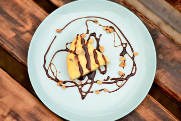 Cottage cheese casserole with date syrup and peanuts on a blue plate