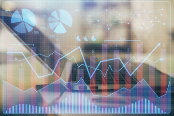 Forex graph hologram on table with computer background. Double exposure. Concept of financial markets.
