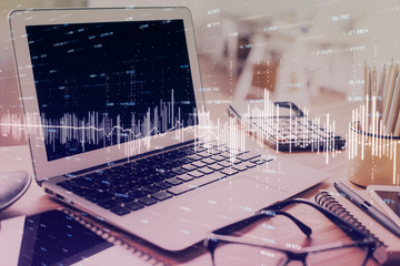 Stock market chart hologram drawn on personal computer background. Double exposure. Concept of...