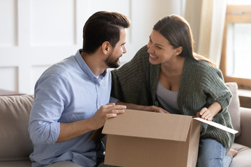 Excited couple unpack package with online order