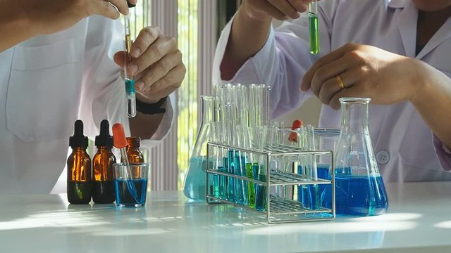 Researcher dropping the reagent or chemical liquid into test tube. Laboratory science, research, chemistry, technology, biology concept.