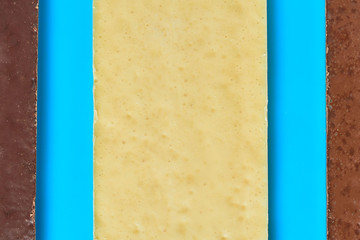 Row of three various whole porous chocolate bars lies on blue table on kitchen. Top view. Close-up