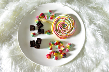 Obraz na płótnie Canvas A dessert made from sugar is a rainbow circle. Brownie Candy in white plate