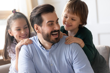 Happy dad have fun playing with kids at home