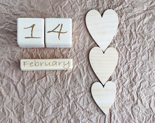 Wooden cubes hearts on crumpled paper congratulations on February 14