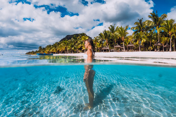 Woman posing in transparent blue ocean. Swimming in blue water at Mauritius