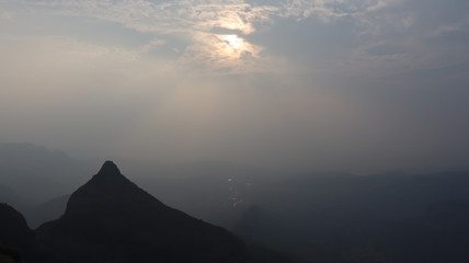Sunset over a dark mountain and blue sky.
