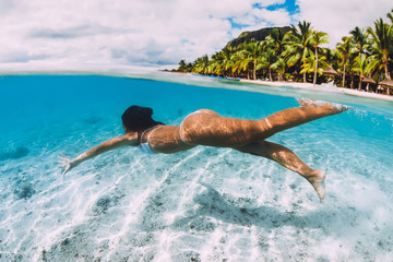 Woman swimming underwater in transparent blue ocean at Mauritius, Le Morne