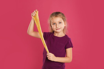 Little girl with slime on pink background