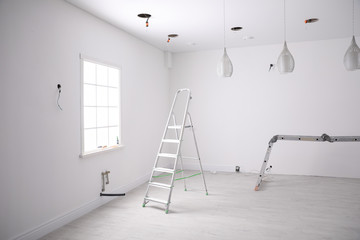 Empty room with stretch ceiling and ladders