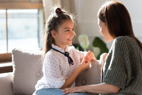 Loving Young Mom And Little Daughter Share Secrets On Couch