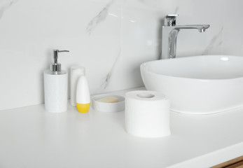 Fototapeta na wymiar New toilet paper roll on countertop in bathroom