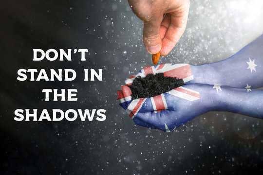 Pray For Australia. Women's hands painted in the flag of Australia hold the soil in which a man's hand plants a seed. Planting forests. Don't stand in the shadows