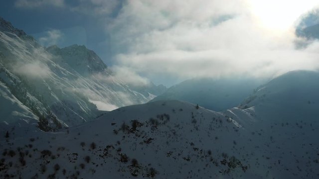 Window view from Glacier Express route in Switzerland of snow capped mountains