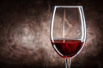 very close up wineglass with red wine on wood background