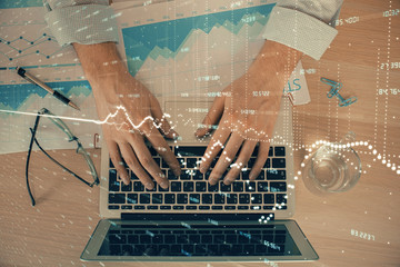 Double exposure of market chart with man working on computer on background. Concept of financial analysis.