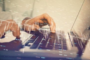 Double exposure of market chart with man working on computer on background. Concept of financial analysis.