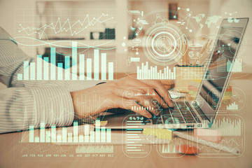 Double exposure of stock market graph with man working on laptop on background. Concept of financial analysis.