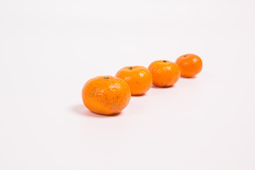 Tangerines on a white background one after another one in the foreground the rest are out of focus