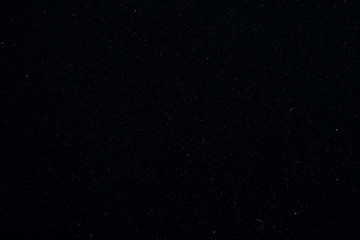 Background texture with a black surface with small specks of white dust