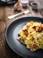 Risotto with seafood on wooden background