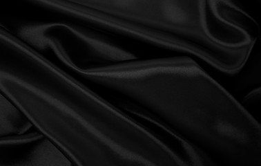 Smooth elegant black silk or satin texture as abstract background. Luxurious background design