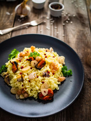 Risotto with seafood on wooden background