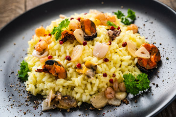 Risotto with seafood on wooden background