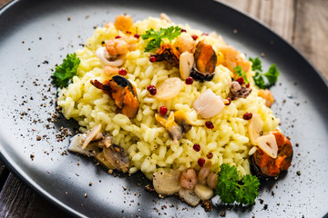 Risotto with seafood on wooden background