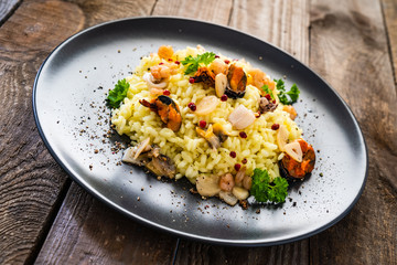 Risotto with seafood on wooden background