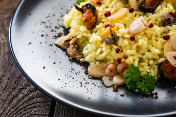 Risotto with seafood on wooden background